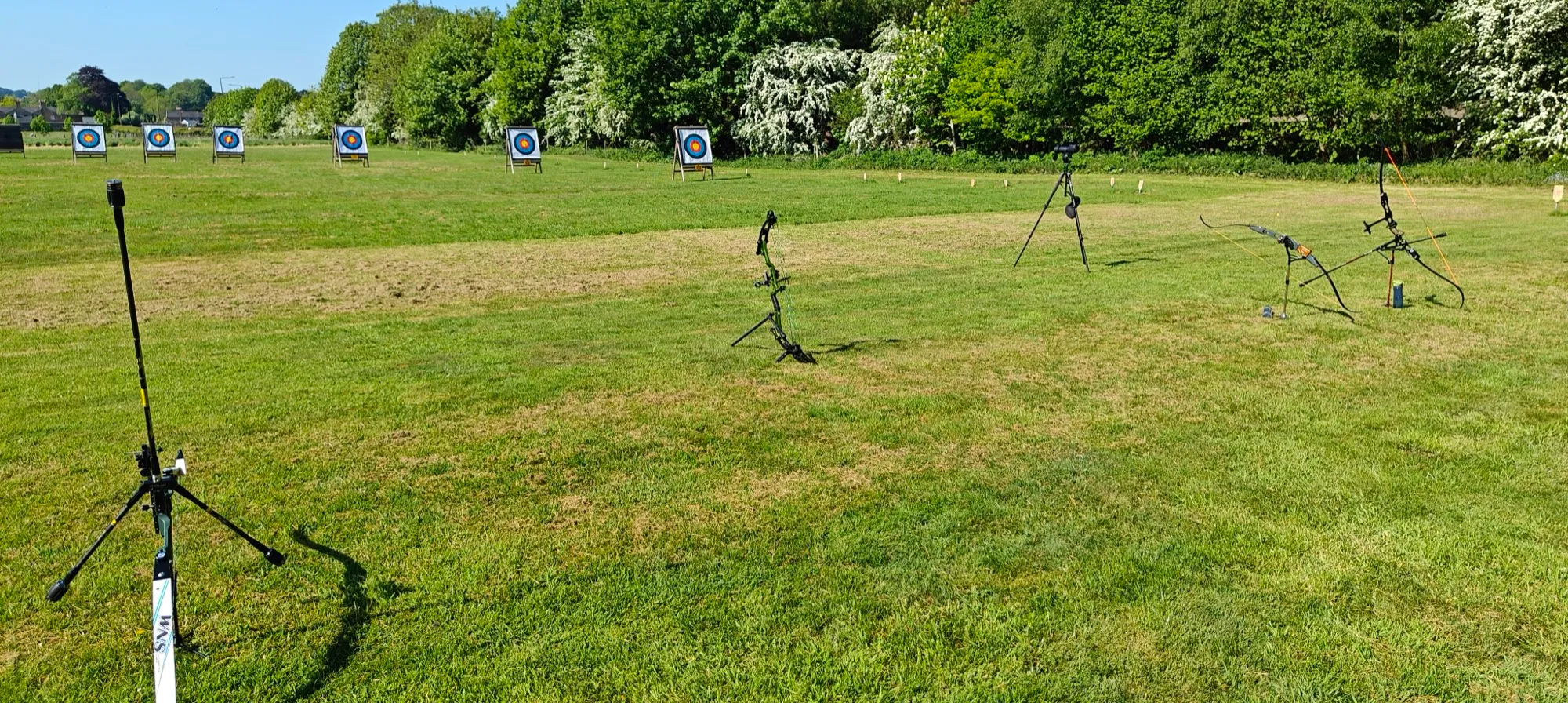 Bows on stands and target faces on the Aequus Archers field at Milford